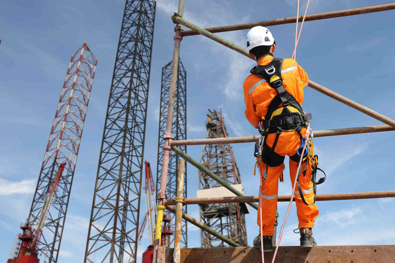 Rope access technician suspended on building performing work at height